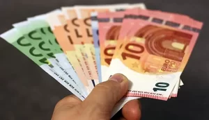 Eine Hand hält aufgefächert verschiedene Geldscheine.