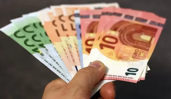 Eine Hand hält aufgefächert verschiedene Geldscheine.