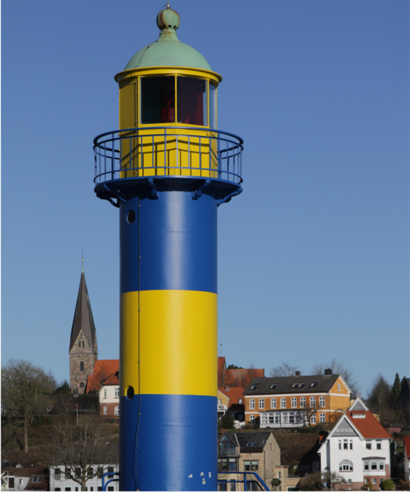 Zu sehen ist der blau-gelbe Leuchtturm von Eckernförde mit der Kirche im Hintergrund