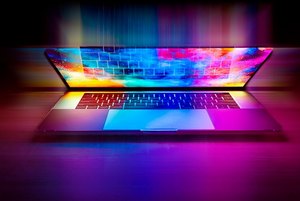 Ein Laptop ist halb geöffnet, viele bunte Inhalte auf dem Bildschirm sind noch zu sehen.